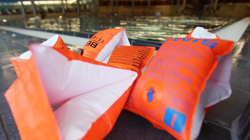 Schwimmfluegel-fuer-Kinder-liegen-vor-einem-Schwimmkurs-am-Beckenrand