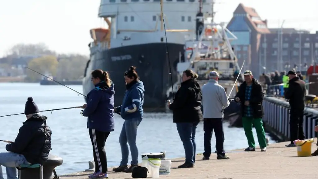 Heringsangler-stehen-an-der-Kaikante-im-Stadthafen