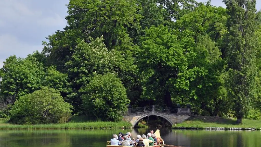 Eine-Gondel-mit-Touristen-faehrt-im-Woerlitzer-Park-ueber-den-See