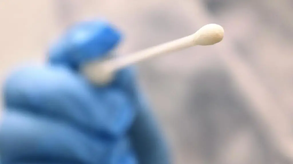 Ein-Arzt-haelt-einen-Tupfer-mit-dem-ein-Abstrich-fuer-einen-Coronatest-gemacht-wird