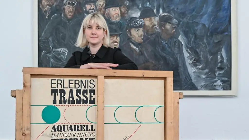 Sabrina-Kotzian-Kuratorin-der-Ausstellung-ueber-die-einstige-Kulturkampagne-der-DDR-zum-Bau-der-Erdgastrasse-Freundschaft-russisch-Drushba-hockt-hinter-einer-alten-Ausstellungskiste