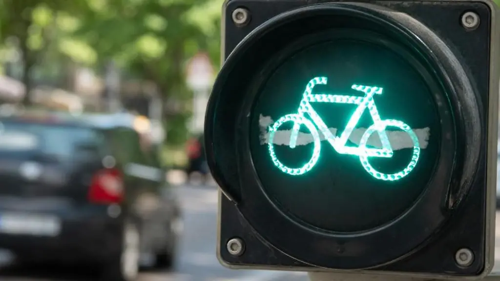 Ein-Auto-faehrt-auf-der-Theodor-Heuss-Strasse-in-Stuttgart-an-einer-gruenen-Fahrradampel-vorbei