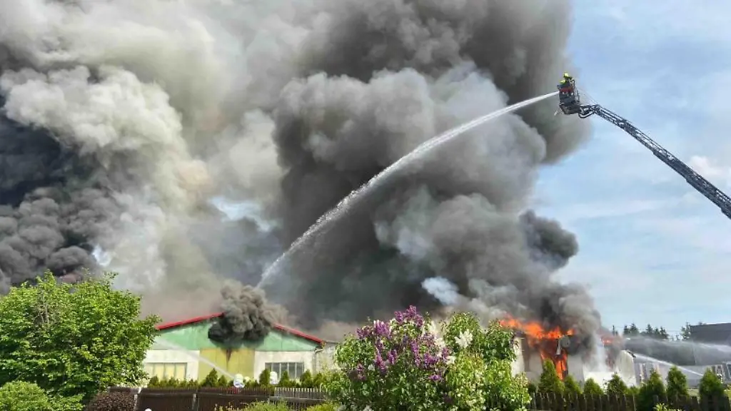 Dichte-Rauchwolken-sind-bei-einem-Brand-von-zwei-Lagerhallen-zu-sehen