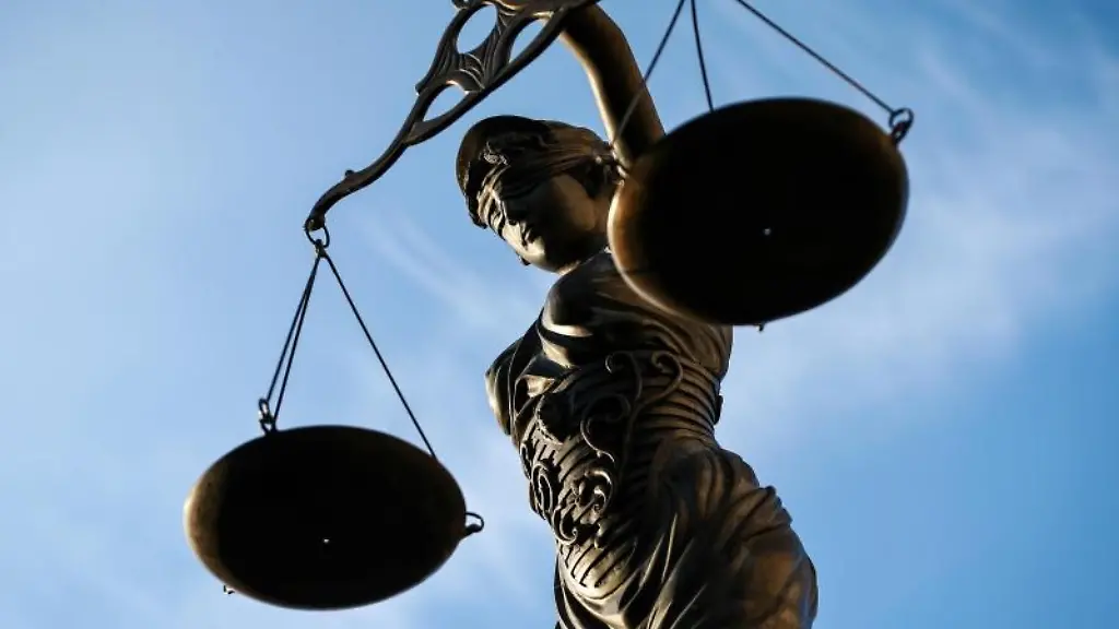 Eine-Statue-der-Justitia-haelt-eine-Waage-in-ihrer-Hand