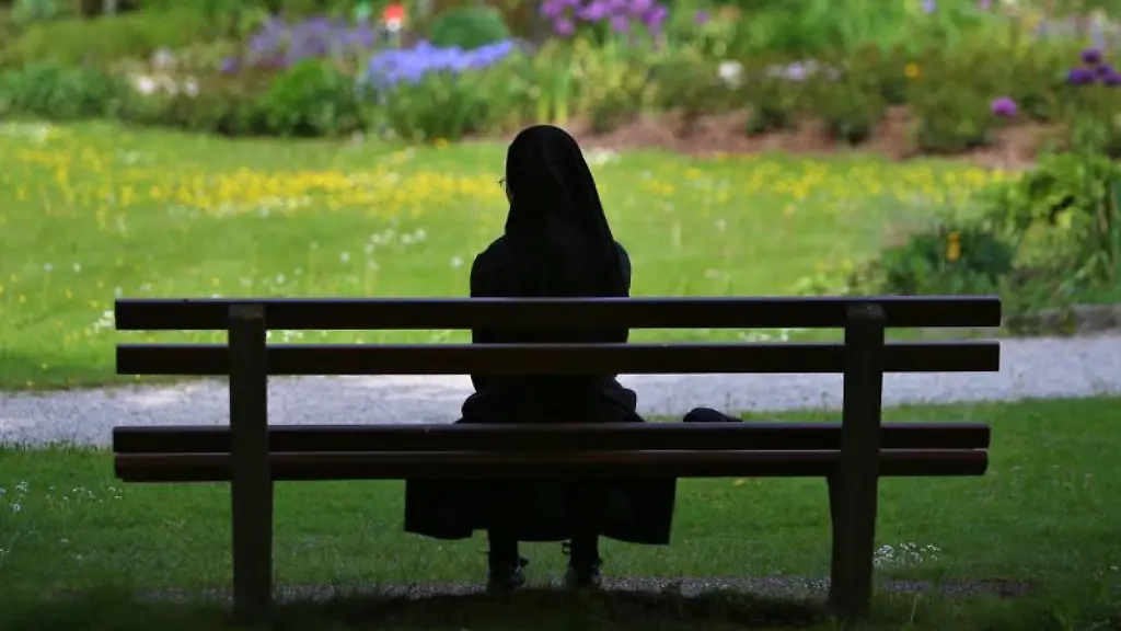 Eine-Ordensschwester-sitzt-auf-einer-Bank