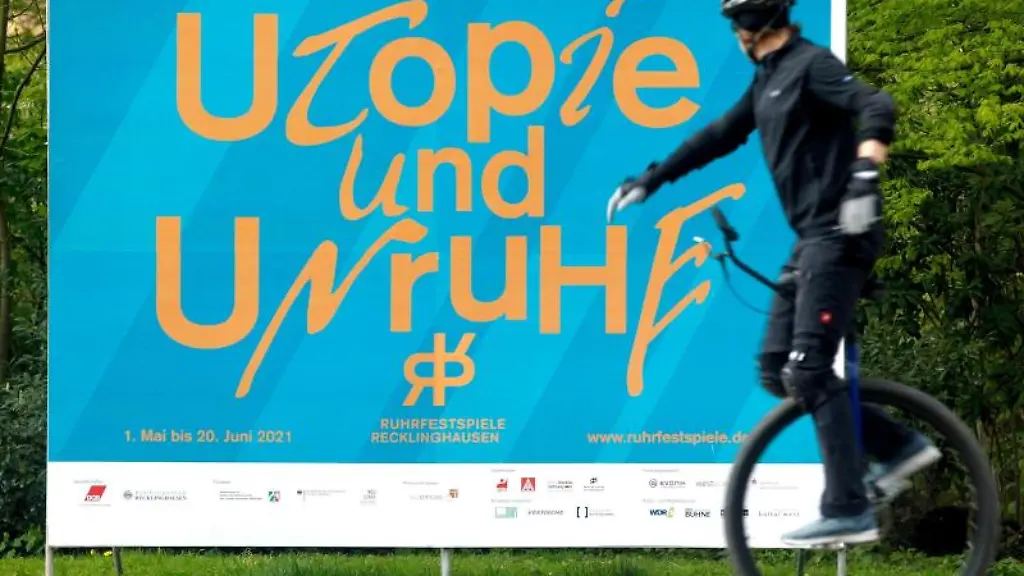 Ein-Einradfahrer-faehrt-an-dem-Eroeffnungsplakat-fuer-die-Ruhrfestspiele