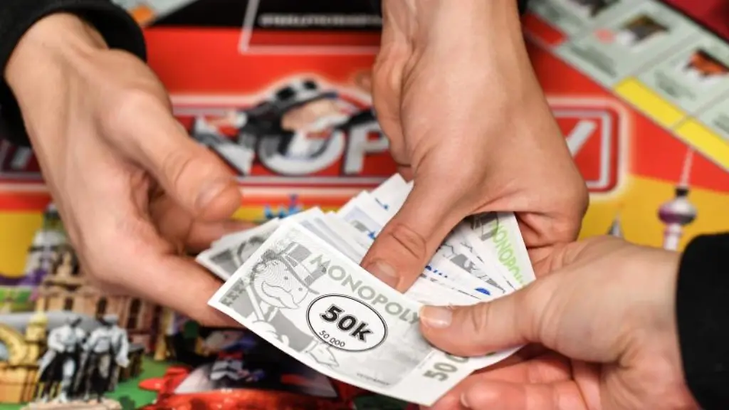 Ein-Kind-und-ein-Erwachsener-halten-Spielgeld-in-den-Haenden