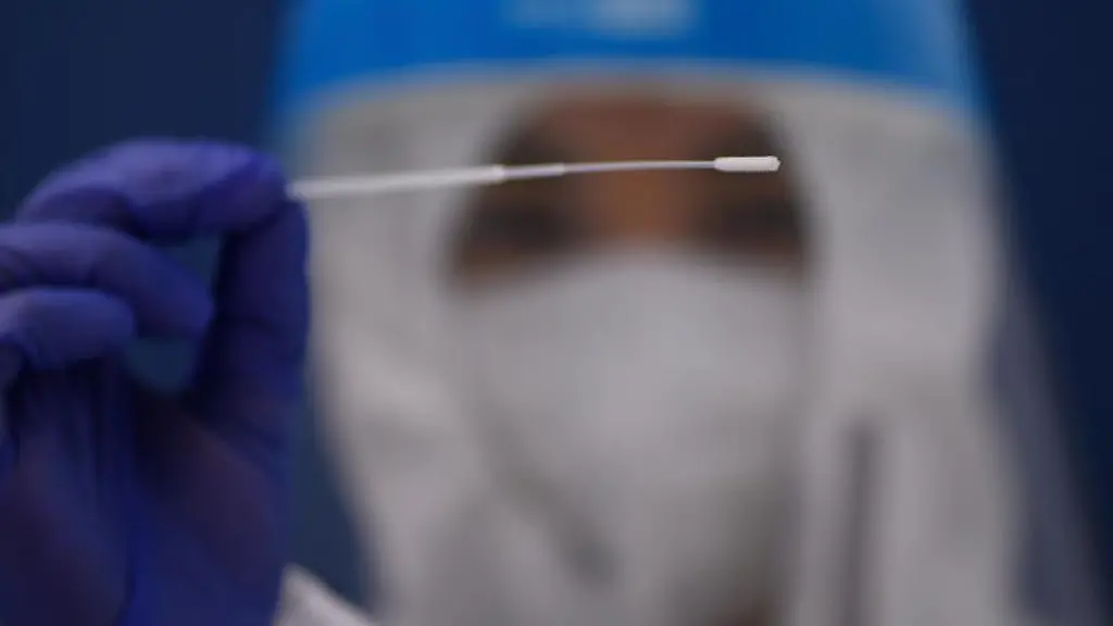 Der-Mitarbeiter-eines-Corona-Testcenter-haelt-ein-Teststab-hoch