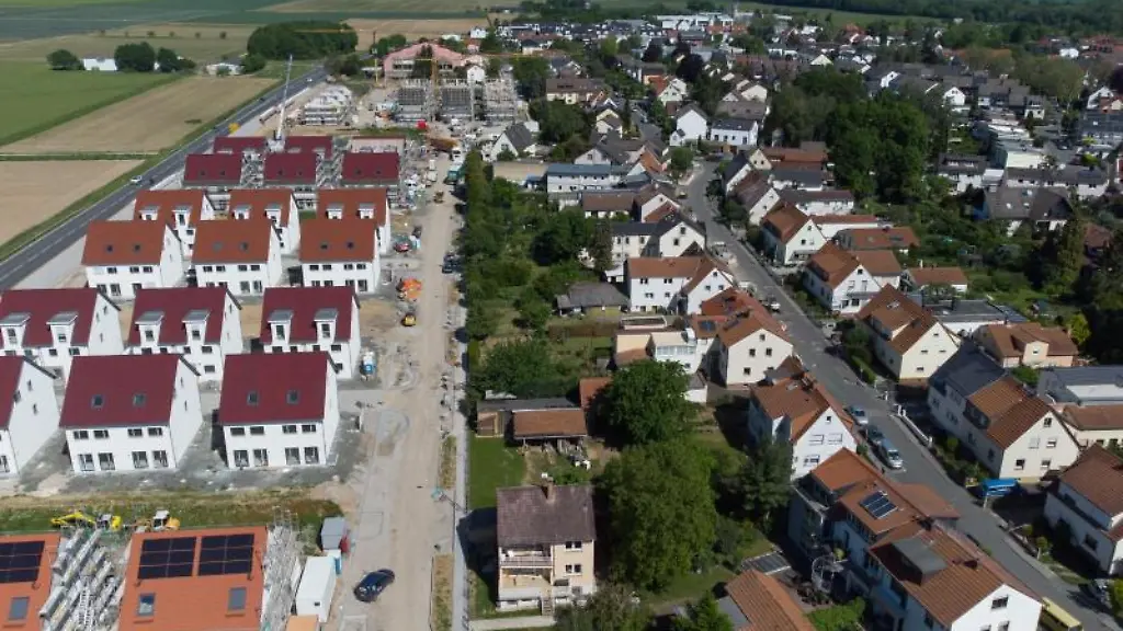 Eine-Strasse-trennt-die-Neubausiedlung-im-Frankfurter-Stadtteil-Nieder-Erlenbach-von-den-Ackerflaechen-waehrend-im-Hintergrund-der-Taunus-zu-erkennen-ist