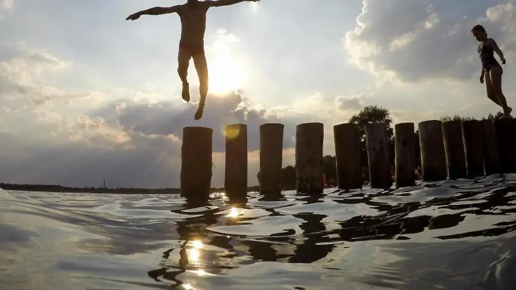 Ein-Junge-springt-von-einer-Buhne-in-einen-See