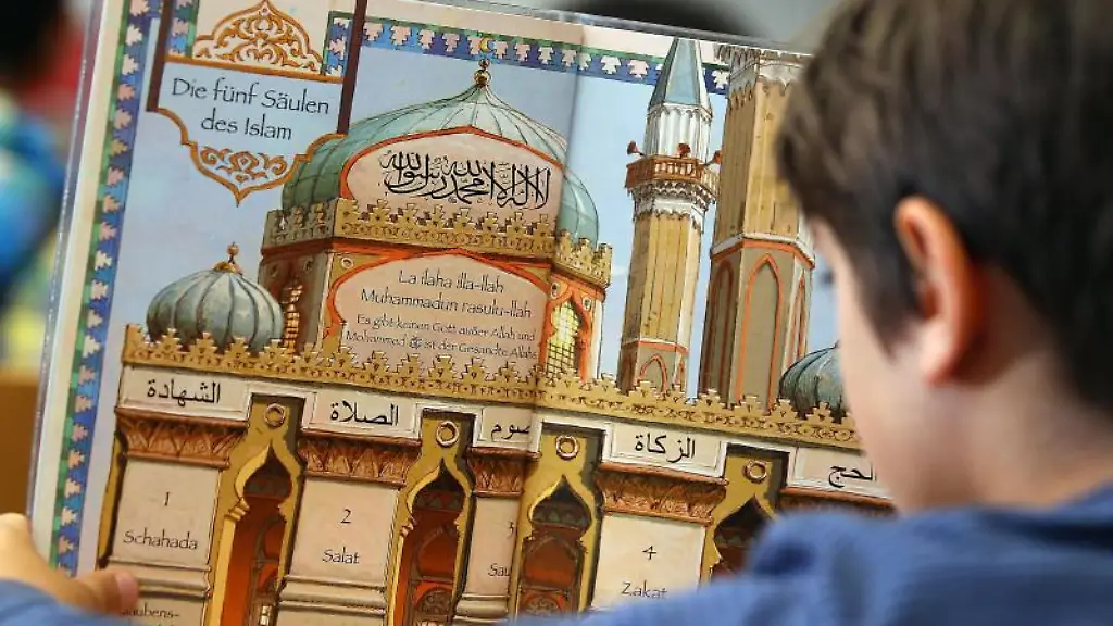 Ein-Junge-liest-waehrend-des-islamischen-Religionsunterrichts-in-einem-Schulbuch