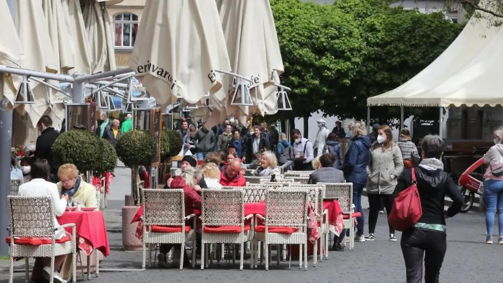 Gaeste-sitzen-vor-einer-Gaststaette-im-Zentrum