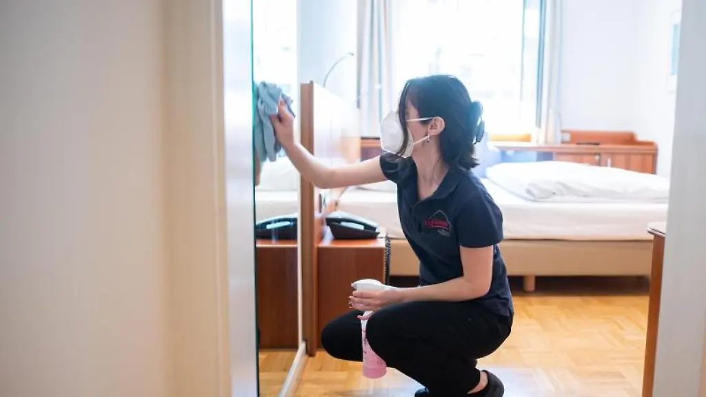 Eine-Frau-reinigt-in-einem-Hotel-ein-Zimmer