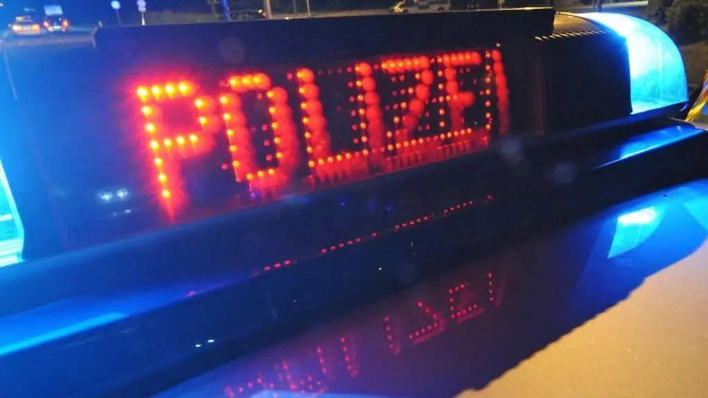 Die-Aufschrift-Polizei-leuchtet-auf-einem-Polizeifahrzeug