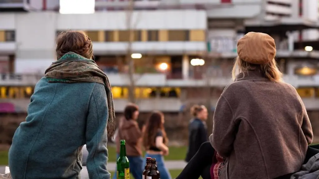 Menschen-sitzen-abends-in-einem-Park-in-Hannover-zusammen