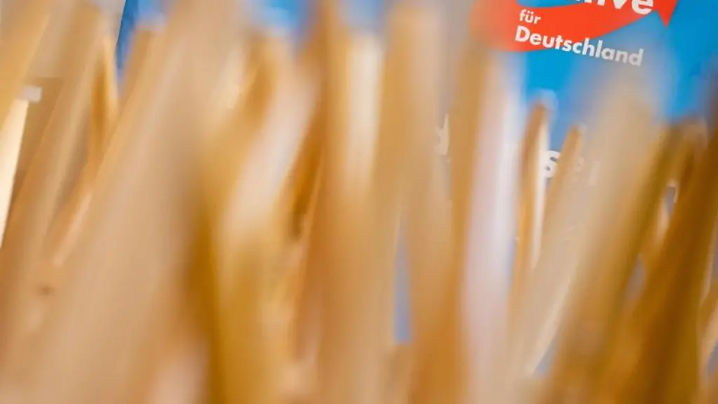 Stuehle-stehen-umgedreht-auf-Tischen-vor-einem-Aufsteller-mit-dem-Logo-der-AfD