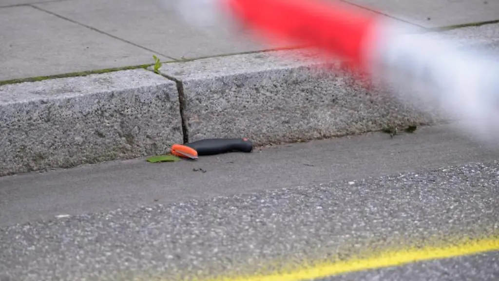 Ein-offenbar-beschaedigtes-Messer-liegt-in-einer-Spurenmarkierung-am-abgesperrten-Tatort