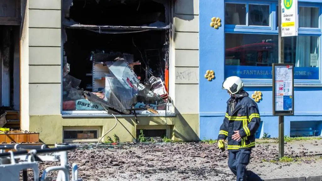 Feuerwehrleute-sichern-das-bei-einem-Feuer-stark-beschaedigte-Wohn-und-Geschaeftshaus-in-der-Innenstadt