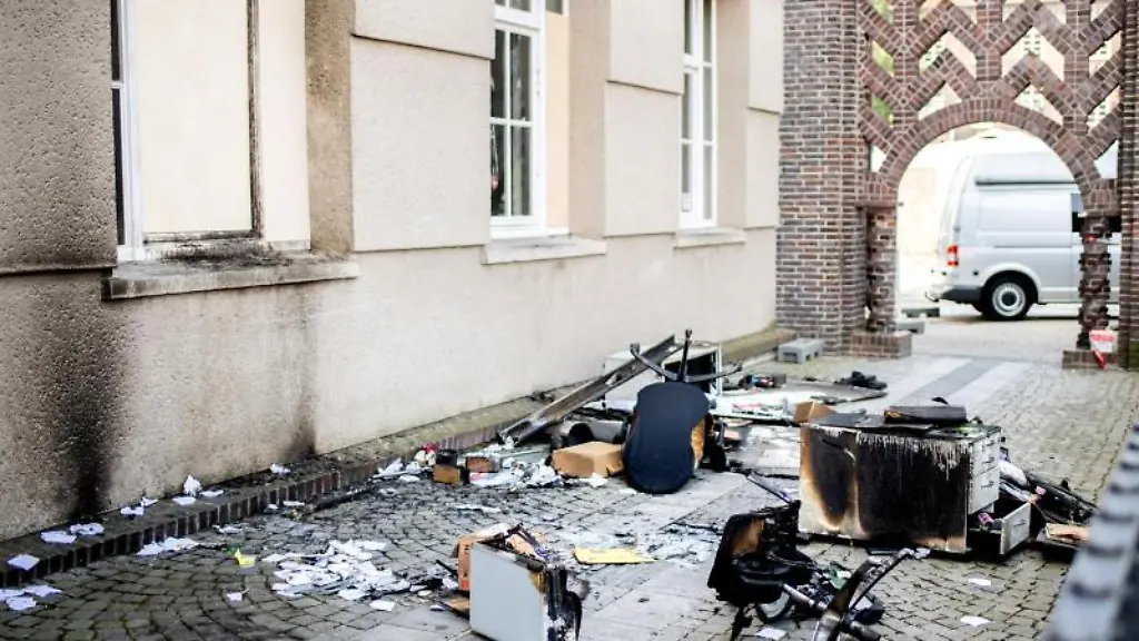 Verkohlte-Moebelstuecke-liegen-auf-einem-Gehweg-vor-dem-Rathaus-in-Delmenhorst