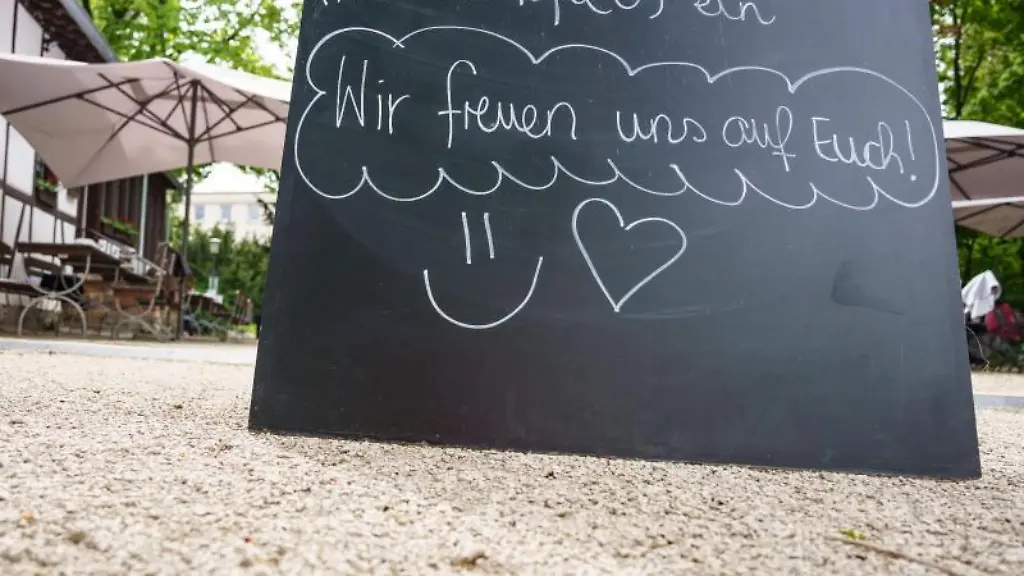 Eine-Tafel-mit-den-Worten-Wir-freuen-uns-auf-Euch-steht-am-Eingang-zu-einer-Gartenterrasse