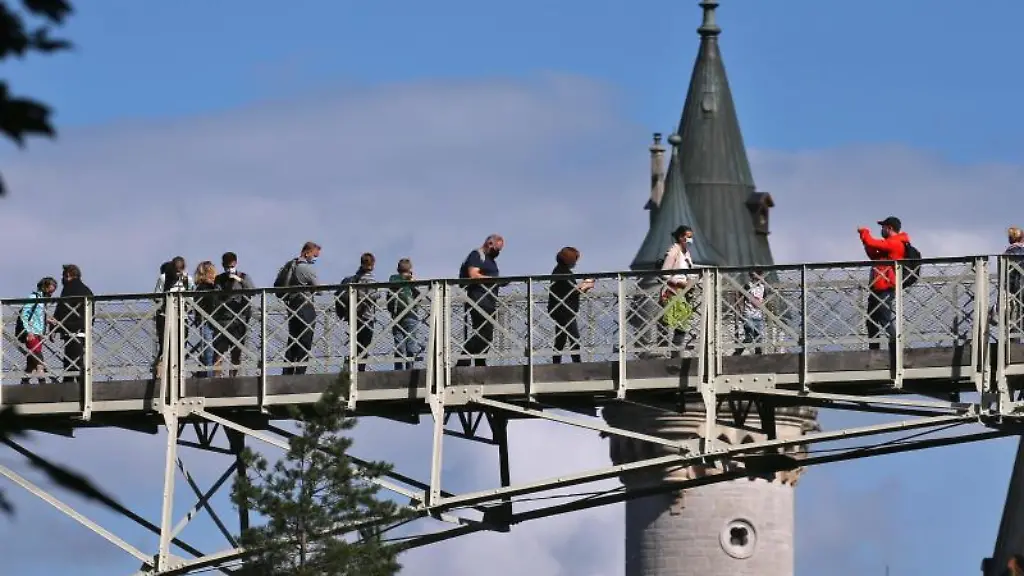 Touristen-stehen-auf-der-Marienbruecke-vor-dem-Schloss-Neuschwanstein
