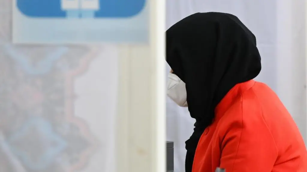 Eine-Frau-wird-im-Kulturzentrum-der-Imam-Sadjad-Moschee-im-Stadtteil-Fechenheim-ueber-die-Impfung-beraten