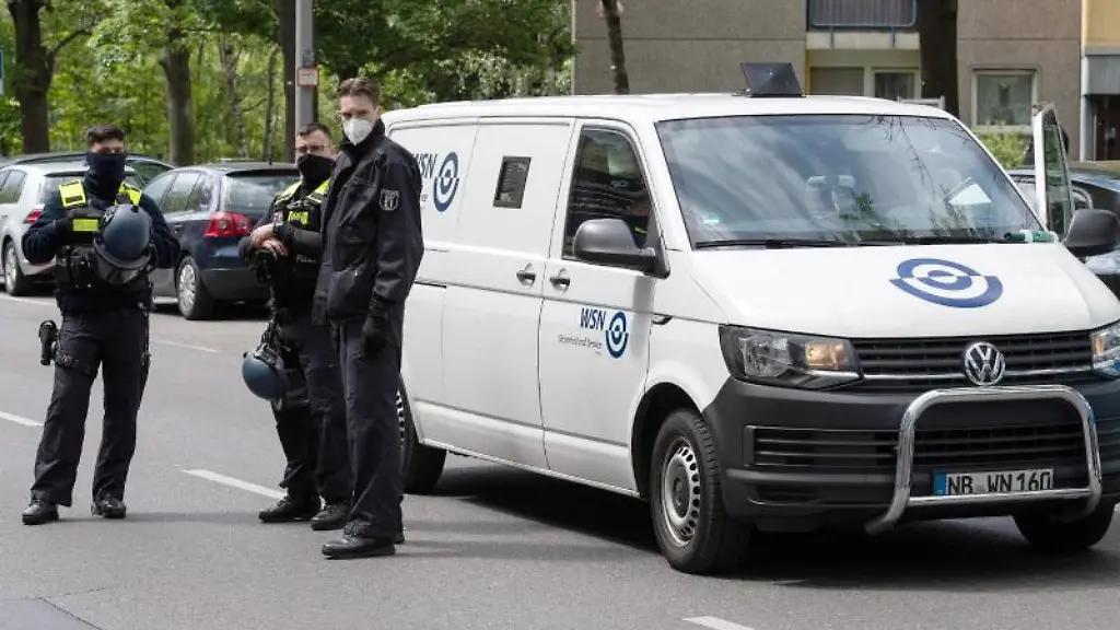 Polizeibeamte-stehen-bei-dem-ueberfallenen-Geldtransporter-vor-einer-Bankfiliale-in-Neukoelln