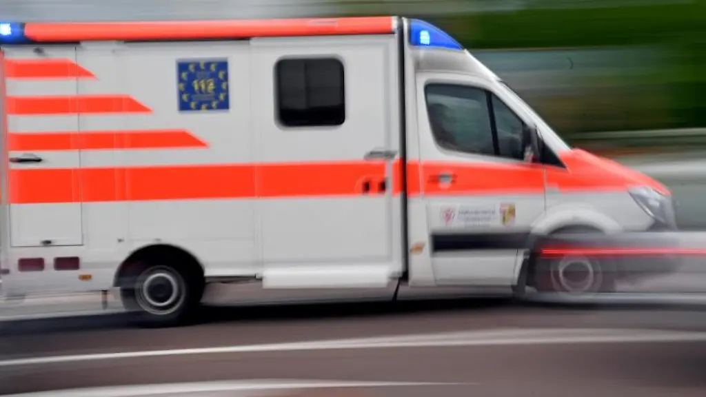 Ein-Krankenwagen-faehrt-mit-Blaulicht-auf-einer-Strasse
