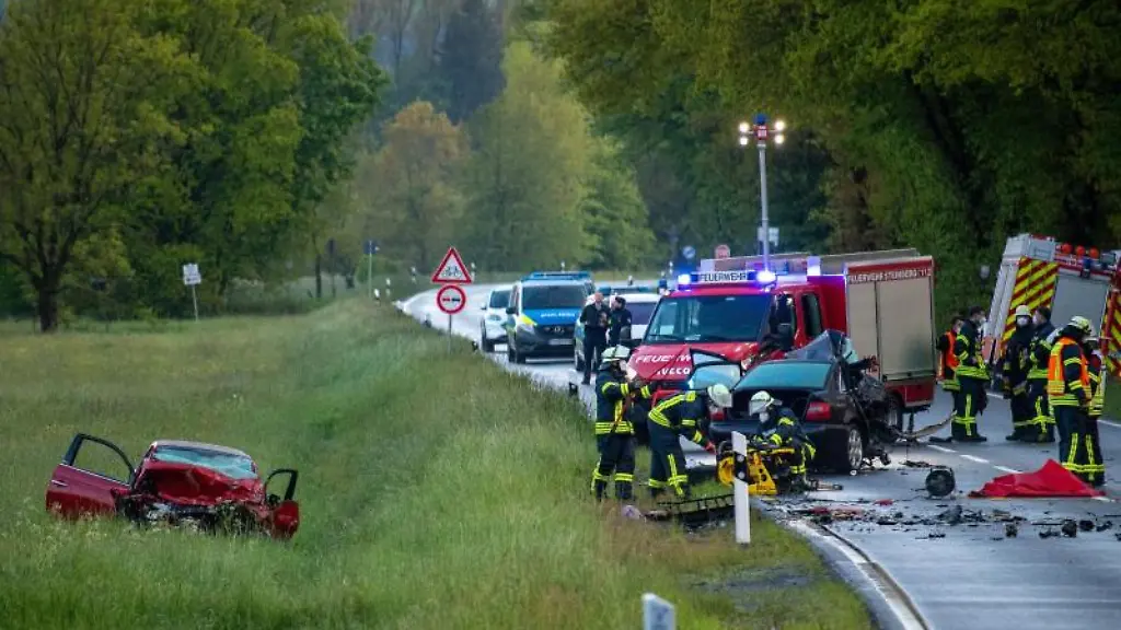 Einsatzkraefte-der-Feuerwehr-untersuchen-den-Unfallort-an-dem-zwei-Autos-zusammengestossen-sind