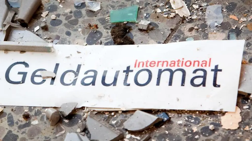 Splitter-und-ein-Schild-mit-der-Aufschrift-Geldautomat-liegen-auf-dem-Boden-vor-einem-gesprengten-Geldautomaten