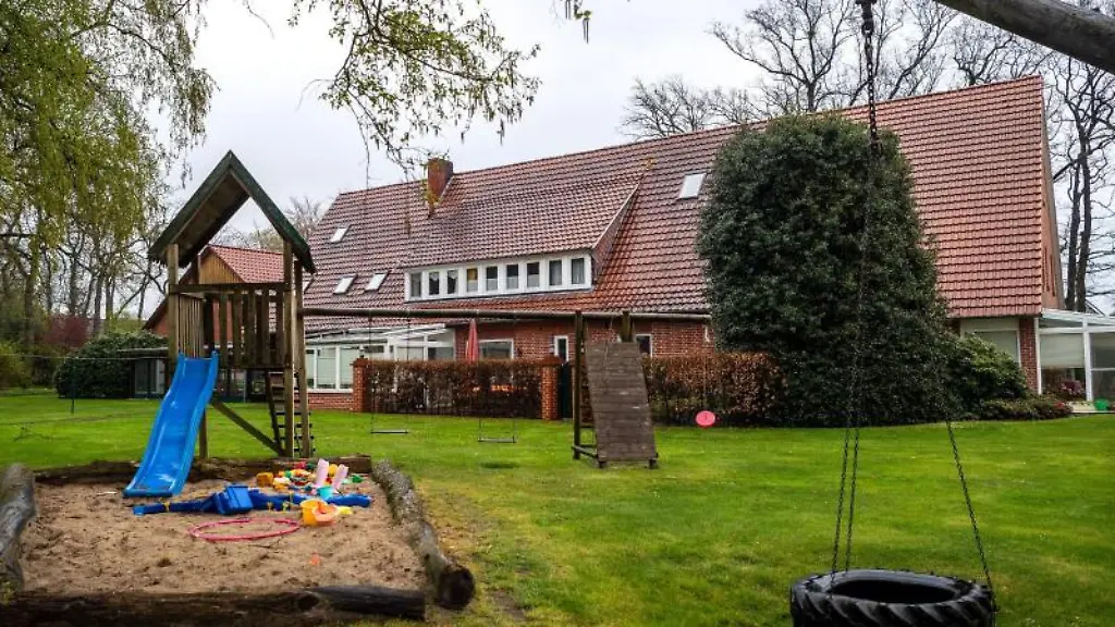 Ein-leerer-Spielplatz-vor-einem-Bauernhof