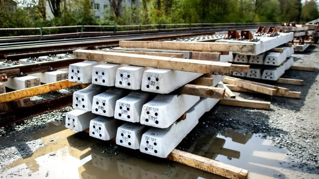 Bahnschwellen-aus-Beton-liegen-auf-einer-Baustelle-am-Gleis-der-Bahnstrecke