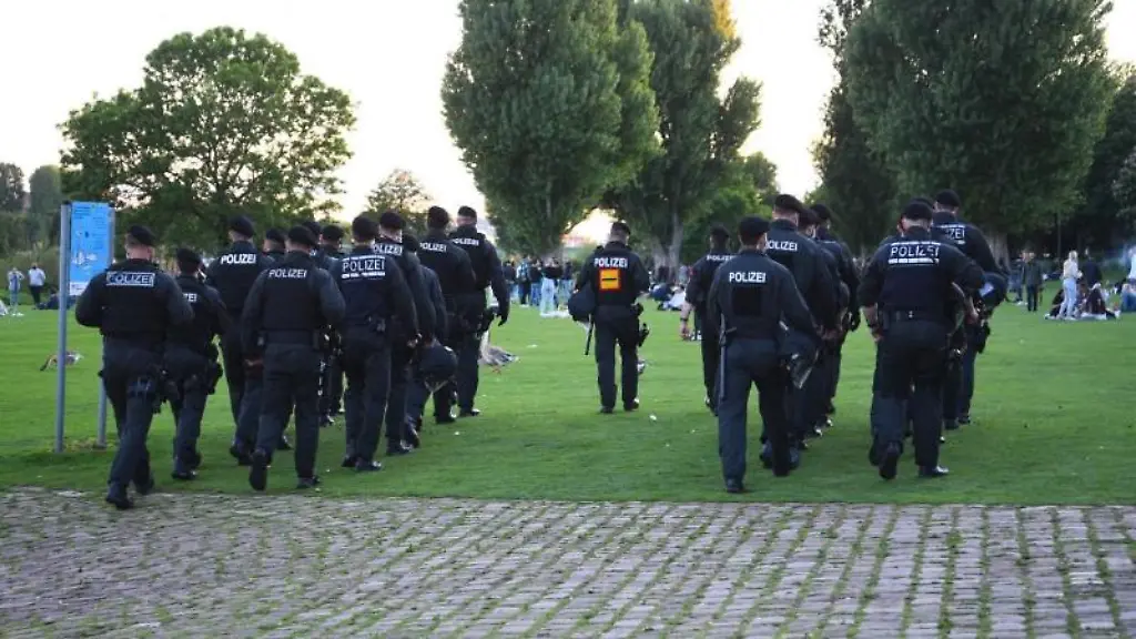 Polizeibeamte-gehen-ueber-die-Neckarwiese-in-Heidelberg