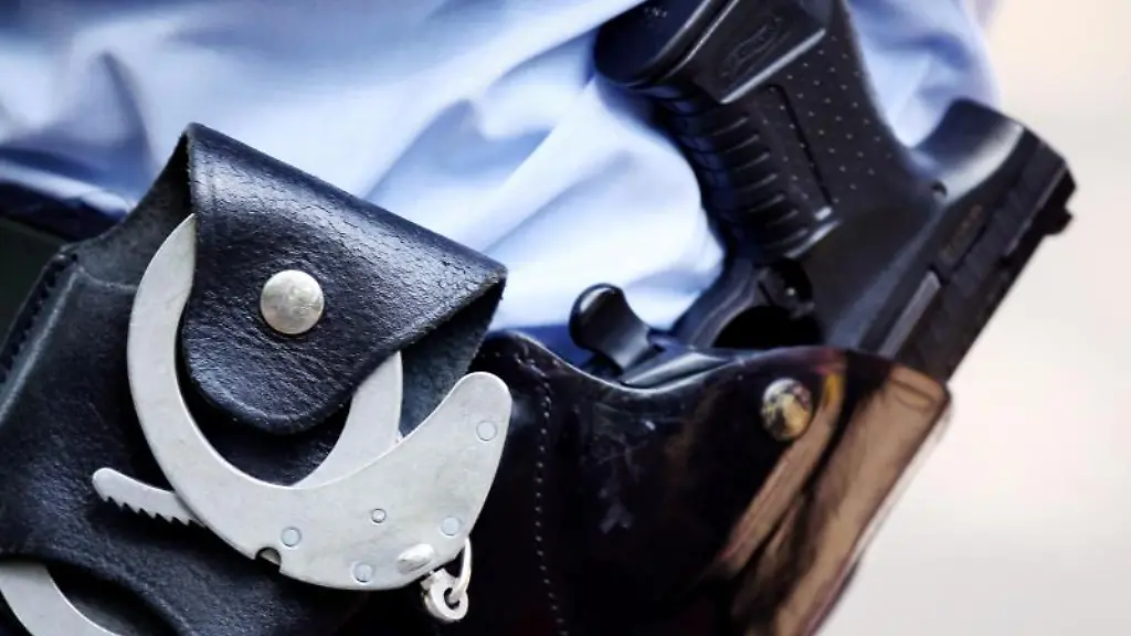 Ein-Polizist-traegt-Handschellen-und-Pistole-am-Guertel