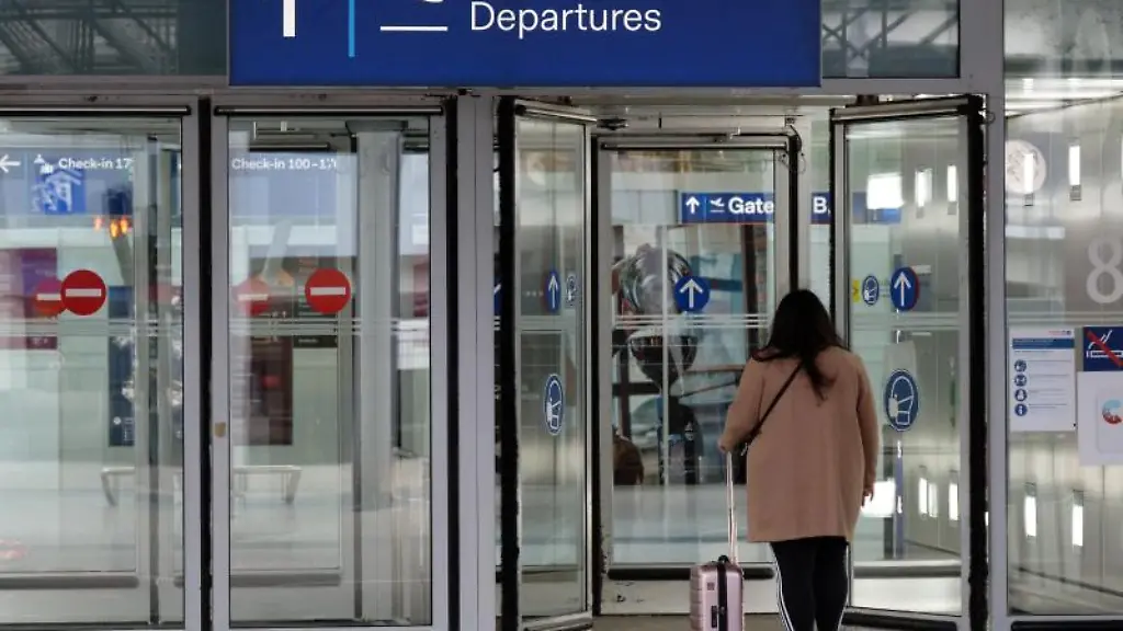 Eine-Reisende-geht-in-das-Abflugterminal-im-Flughafen-Duesseldorf