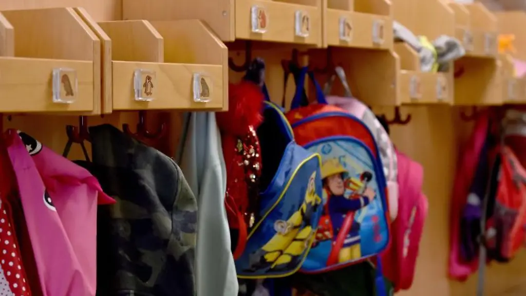 Jacken-und-Rucksaecke-haengen-in-einer-Kita-an-Haken-im-Flur