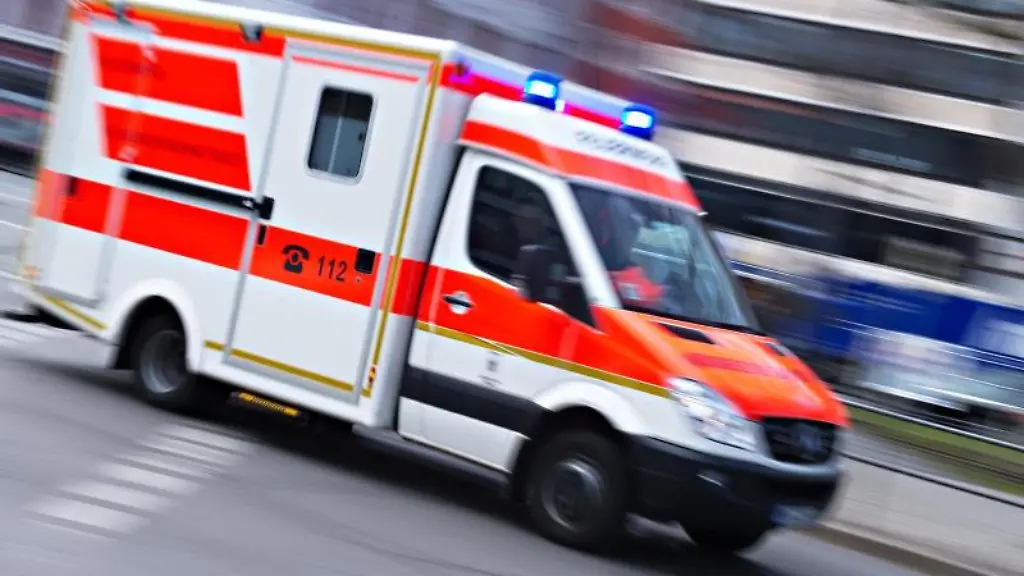 Ein-Rettungswagen-mit-der-Aufschrift-112-faehrt-mit-Blaulicht-durch-die-Stadt