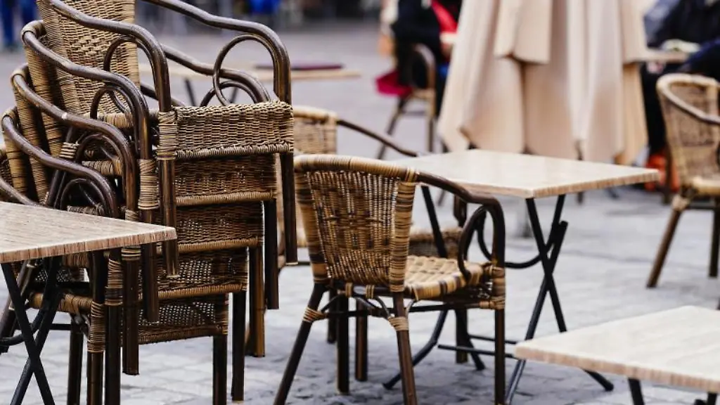 Tische-und-aufeinandergestapelte-Stuehle-stehen-auf-einem-Marktplatz