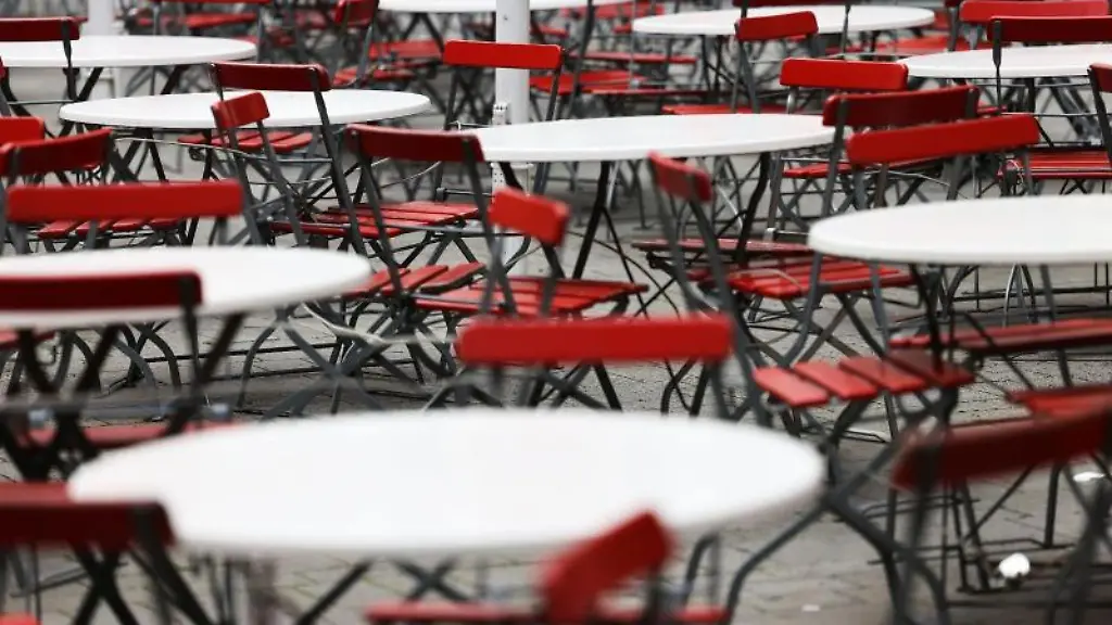 Leere-Tische-und-Stuehle-stehen-vor-einem-Lokal