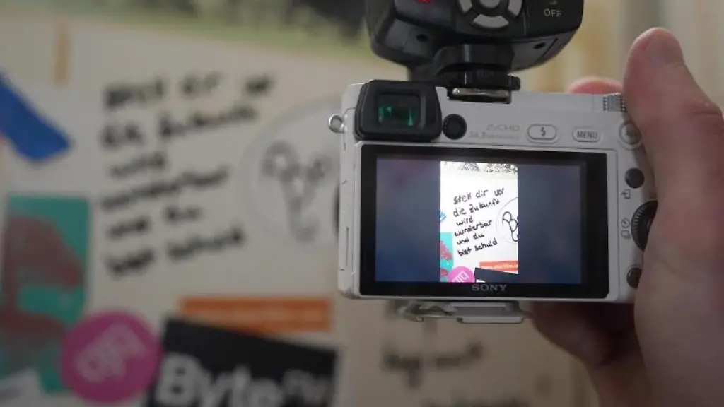 Stefan-Schoder-fotografiert-einen-Spruch-an-der-Toilettentuer-der-Bar-Kleinraumdisko