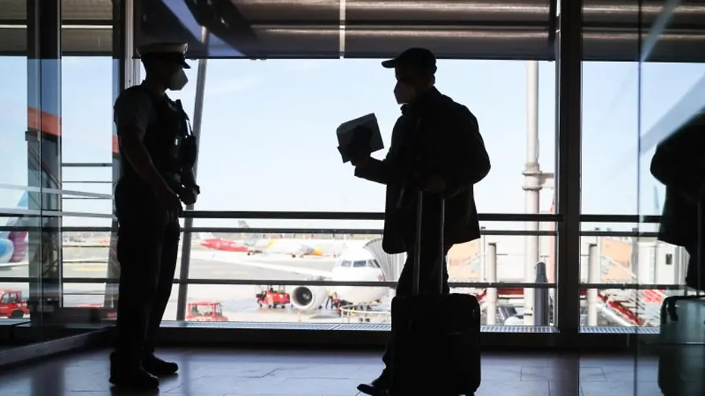 Ein-Bundespolizist-kontrolliert-einen-Passagier-am-Flughafen-Hamburg