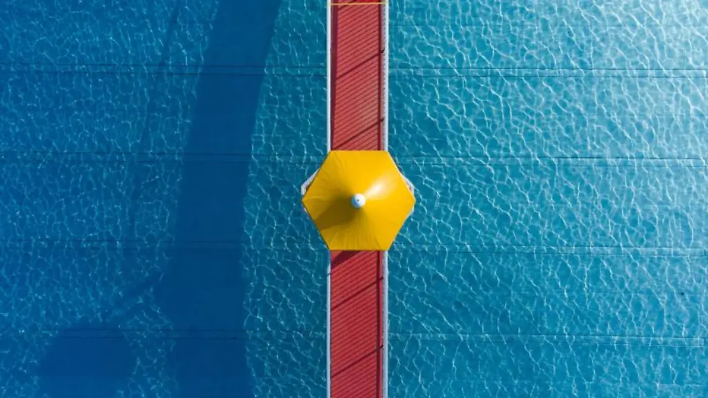 Ein-gelber-Sonnenschirm-steht-in-einem-Frankfurter-Freibad-auf-einem-Steg