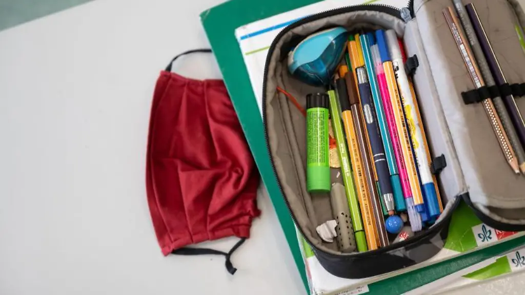 Eine-Atemschutzmaske-liegt-neben-einem-Federmaeppchen