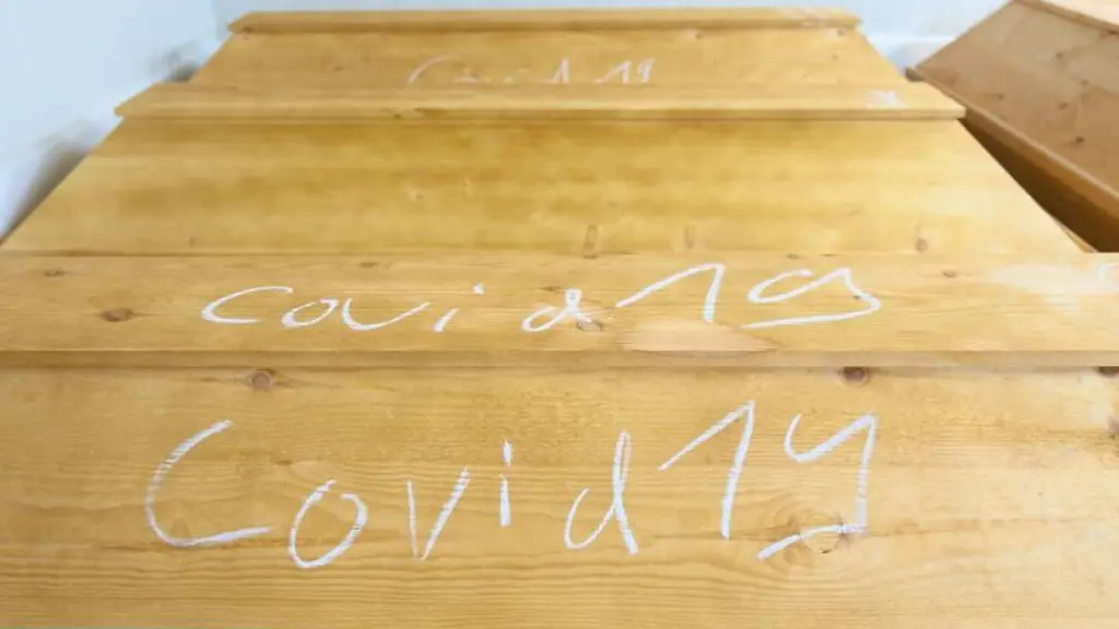 Mit-Kreide-geschrieben-steht-Covid-19-auf-einem-Sarg