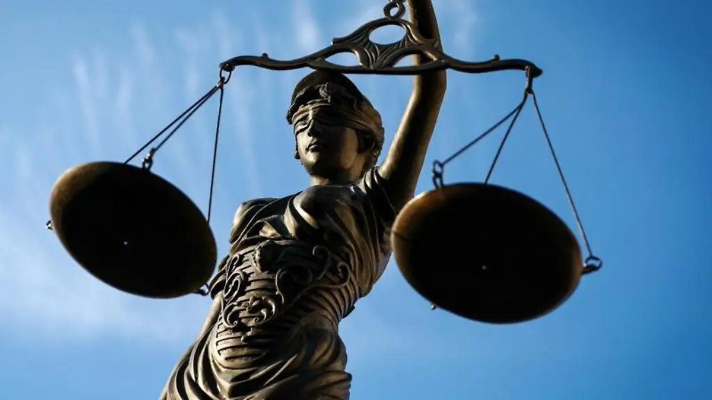 Eine-Statue-der-Justitia-haelt-eine-Waage-in-ihrer-Hand