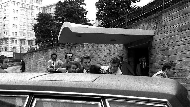Reagan wird am 30. März 1981 in der Limousine in Sicherheit gebracht.