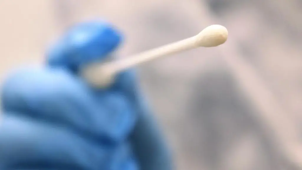 Ein-Arzt-haelt-einen-Tupfer-mit-dem-ein-Abstrich-fuer-einen-Coronatest-gemacht-wird