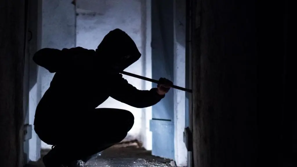 Ein-Mann-hebelt-mit-einem-Brecheisen-eine-Tuer-im-Keller-eines-Wohnhauses-auf