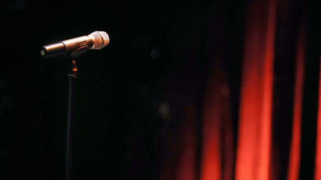 Ein-Mikrofon-steht-in-einem-Theater-vor-einem-roten-Vorhang