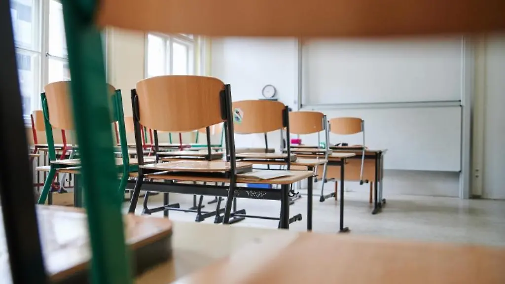 In-einem-leeren-Klassenzimmer-stehen-die-Stuehle-auf-den-Tischen